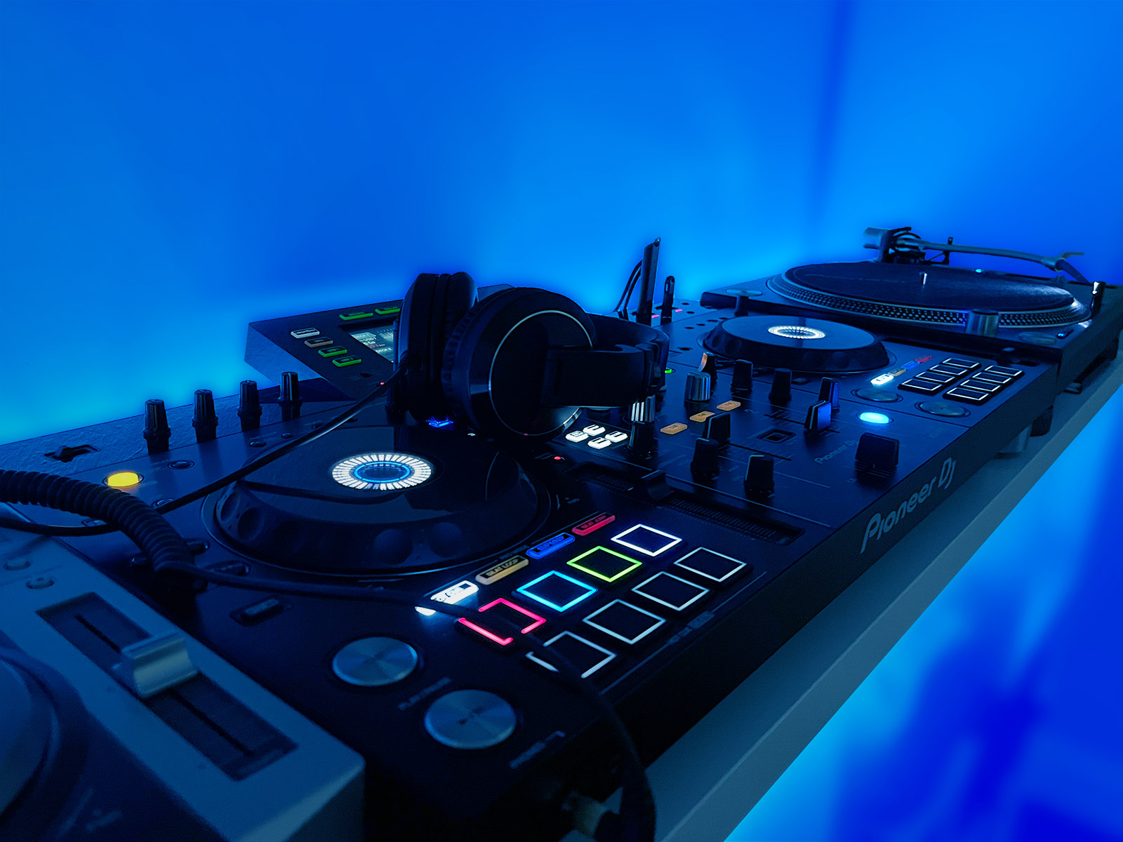 Pioneer XDJ-RX2, headphones and turntable with blue lighting